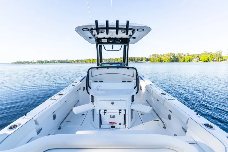 Slide: The Image of 2027 Sea Hunt Ultra 265SE boat on calm water, showcasing spacious deck and modern design. - 14