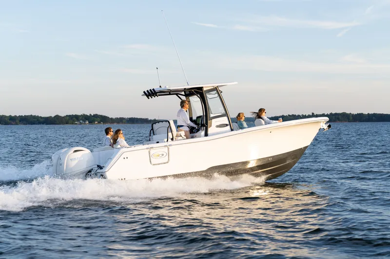 Slide: The Image of 2027 Sea Hunt Ultra 265SE boat cruising on a serene lake with passengers enjoying the ride. - 41