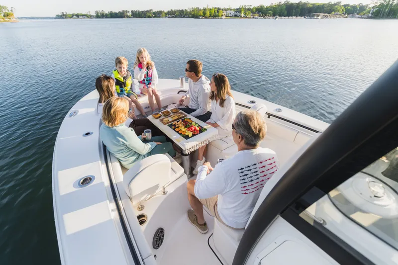 Slide: The Image of Family enjoying a meal on a 2027 Sea Hunt Ultra 265SE boat. - 39