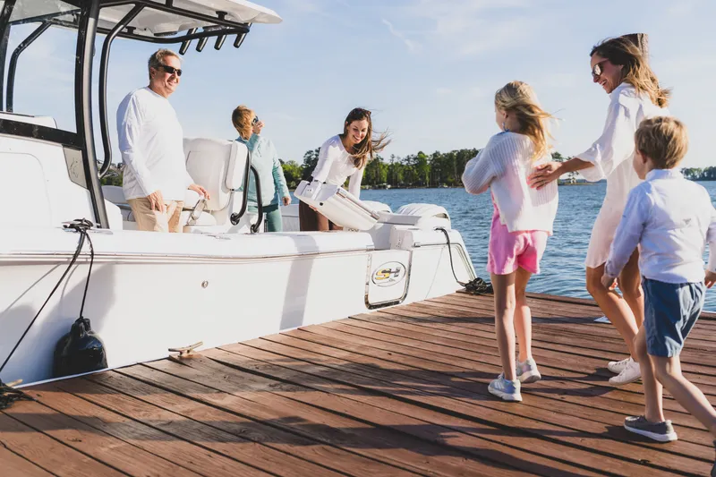 Slide: The Image of Family enjoying a day on the Sea Hunt Ultra 265SE boat, dockside, 2027 model. - 27