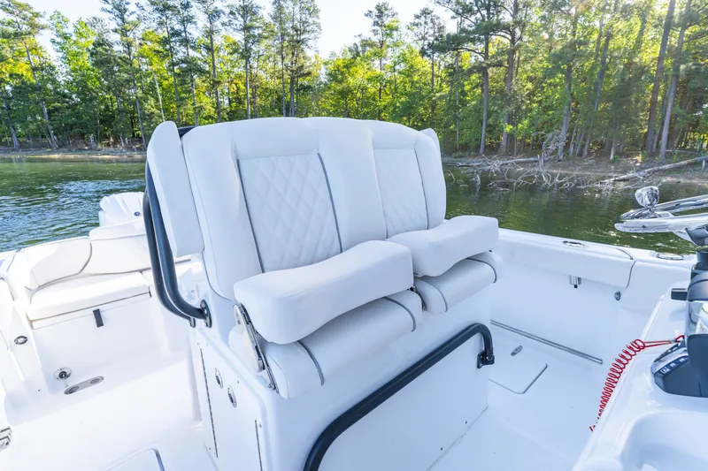 Slide: The Image of Luxurious seating on 2027 Sea Hunt Ultra 265SE boat, surrounded by serene forested waters. - 19