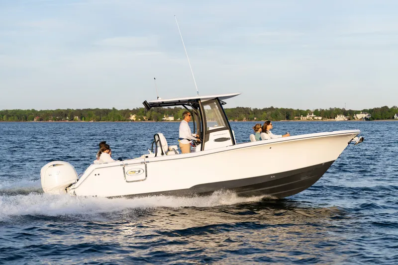 Slide: The Image of 2027 Sea Hunt Ultra 265SE boat cruising on a serene lake with passengers onboard. - 40