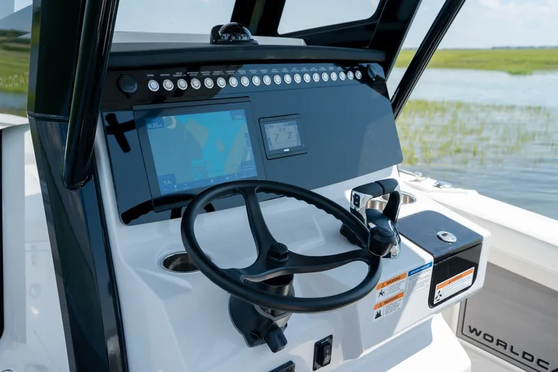 Slide: The Image of 2026 World Cat 265 CC-X boat dashboard with steering wheel and navigation display. - 24