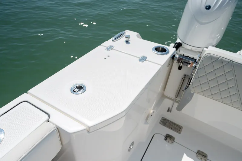 Slide: The Image of 2026 World Cat 265 CC-X boat deck with seating and cup holder, on calm water. - 42