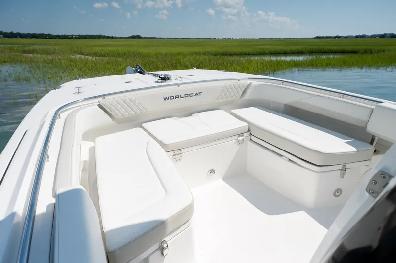 Slide: The Image of 2026 World Cat 265 CC-X boat interior with white seating, set against a serene marshland backdrop. - 15