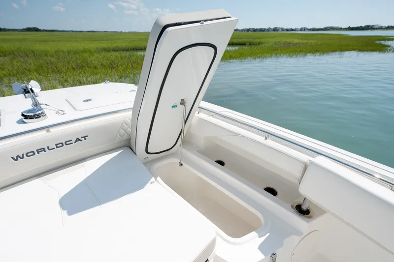 Slide: The Image of 2026 World Cat 265 CC-X boat with open storage compartment, docked by serene waters. - 17