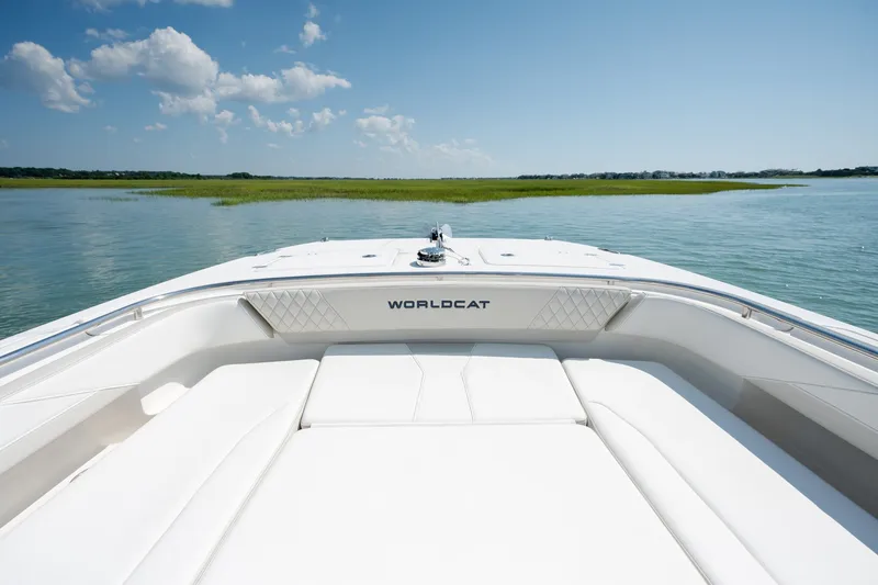 Slide: The Image of 2026 World Cat 265 CC-X boat on calm water under a clear blue sky. - 13