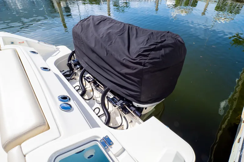 Slide: The Image of 2019 Boston Whaler 350 Realm boat engine covered, docked on calm water. - 114