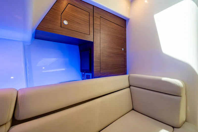 Slide: The Image of Interior of 2019 Boston Whaler 350 Realm with wood cabinetry and cushioned seating. - 25