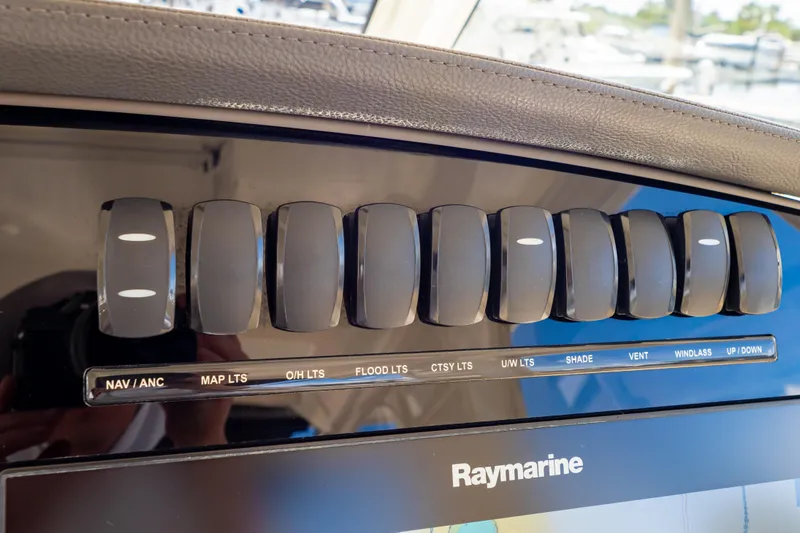 Slide: The Image of Control panel of a 2019 Boston Whaler 350 Realm boat with labeled switches. - 102