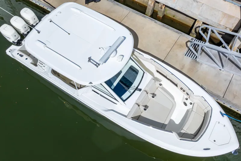 Slide: The Image of 2019 Boston Whaler 350 Realm docked, aerial view showcasing sleek design and triple engines. - 54