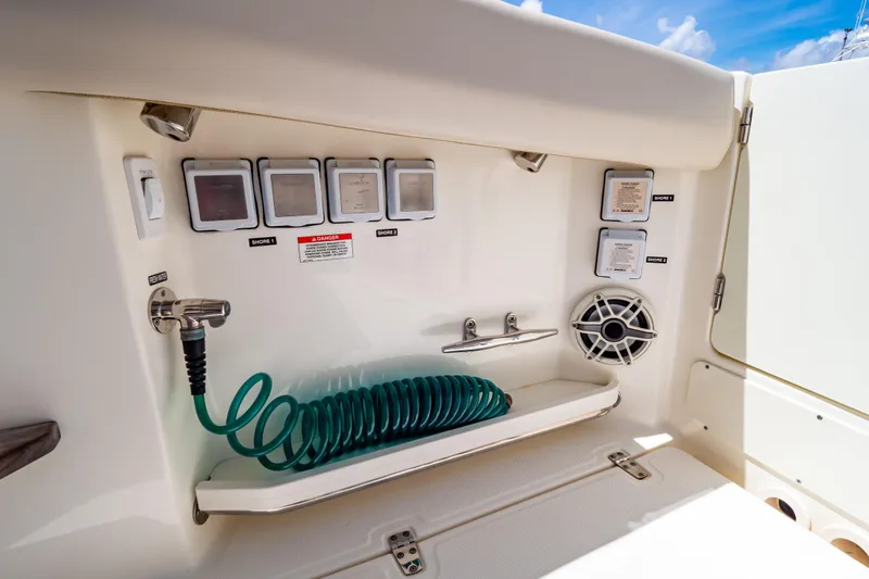 Slide: The Image of 2019 Boston Whaler 350 Realm boat utility panel with hose and speaker. - 49