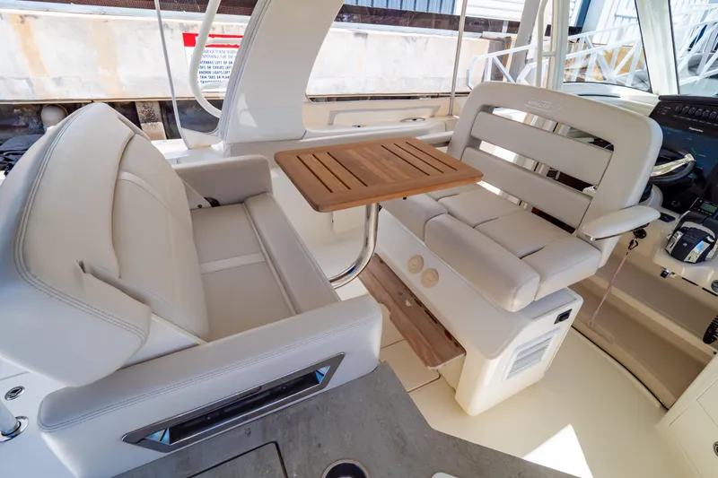 Slide: The Image of 2019 Boston Whaler 350 Realm interior with plush seating and wooden table. - 72