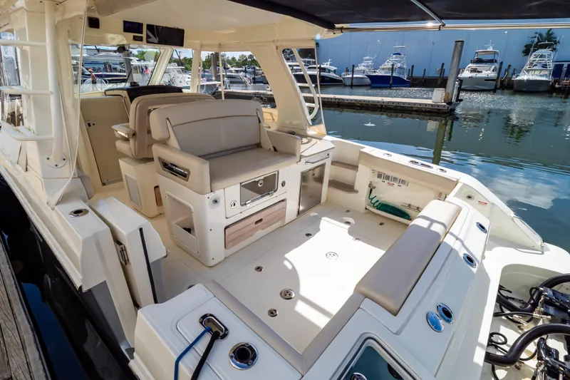 Slide: The Image of 2019 Boston Whaler 350 Realm boat interior with seating and docked marina view. - 110