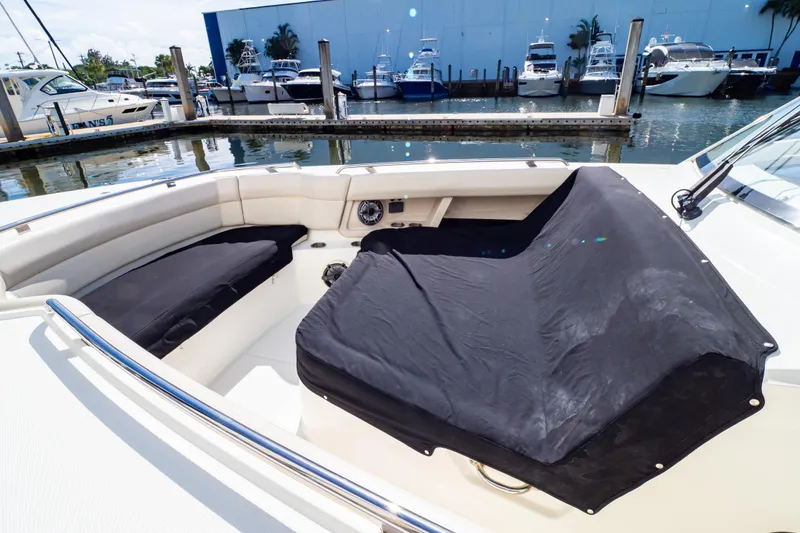 Slide: The Image of 2019 Boston Whaler 350 Realm boat interior with covered seating at marina. - 112