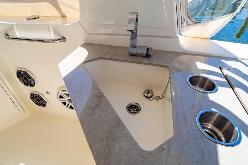 Slide: The Image of 2019 Boston Whaler 350 Realm boat sink and countertop with speakers and cup holders. - 85