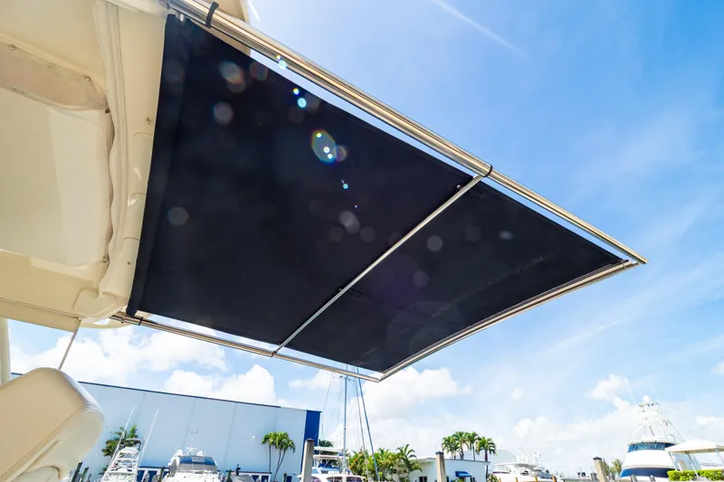 Slide: The Image of 2019 Boston Whaler 350 Realm boat with extended sunshade under clear blue sky. - 56