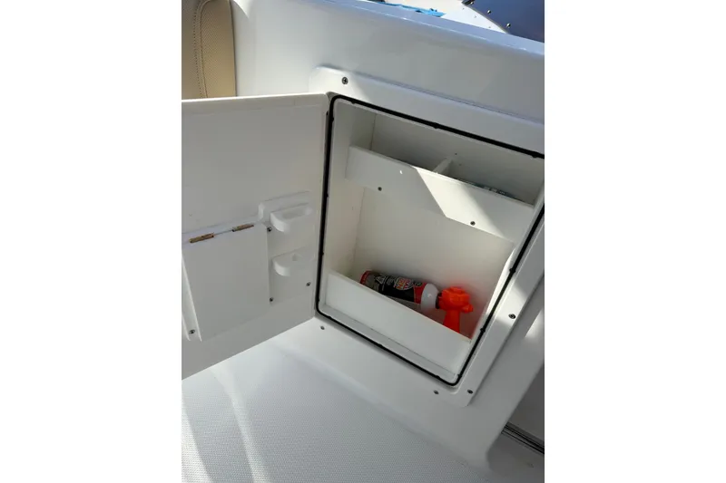 Slide: The Image of Open storage compartment on 2018 Sea Hunt Gamefish 27 boat, containing safety equipment. - 25