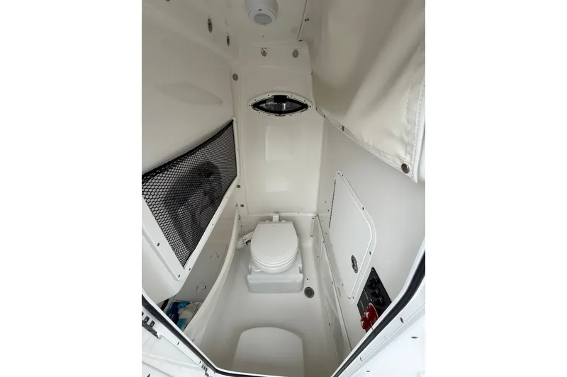 Slide: The Image of 2018 Sea Hunt Gamefish 27 boat interior with compact marine toilet and storage. - 18
