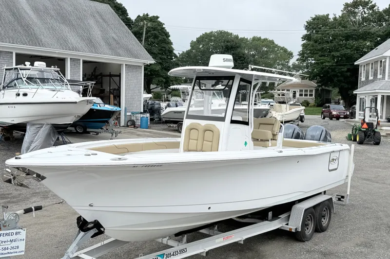 The Image of 2018 Sea Hunt Gamefish 27 boat on trailer at marina, surrounded by other boats. - 0