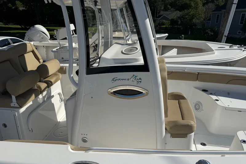 Slide: The Image of 2018 Sea Hunt Gamefish 27 boat interior with beige seating and console. - 22