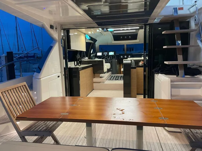 Slide: The Image of Interior view of 2016 Ferretti Yachts 550, featuring a modern dining area and helm station. - 23