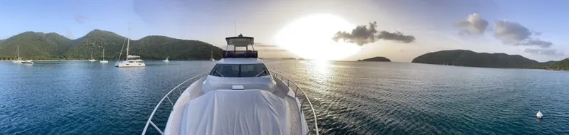 Slide: The Image of Ferretti Yachts 550 (2016) cruising at sunset in a serene bay with surrounding hills. - 2