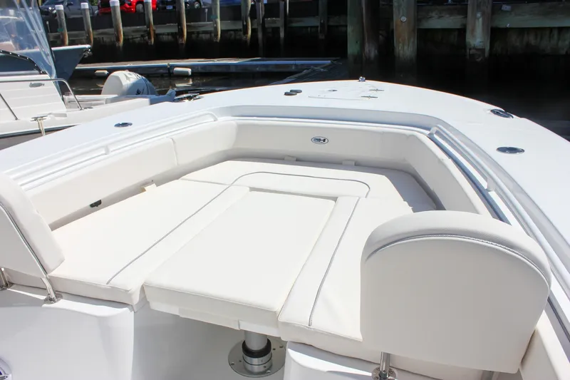 Slide: The Image of 2027 Sea Hunt Ultra 265SE boat with spacious white seating area at the dock. - 34