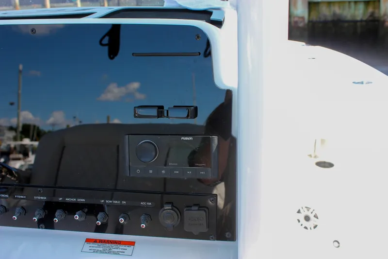 Slide: The Image of Control panel of 2027 Sea Hunt Ultra 265SE boat with audio system and switches. - 27
