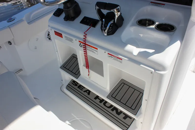 Slide: The Image of 2027 Sea Hunt Ultra 265SE boat console with controls and cup holders. - 22