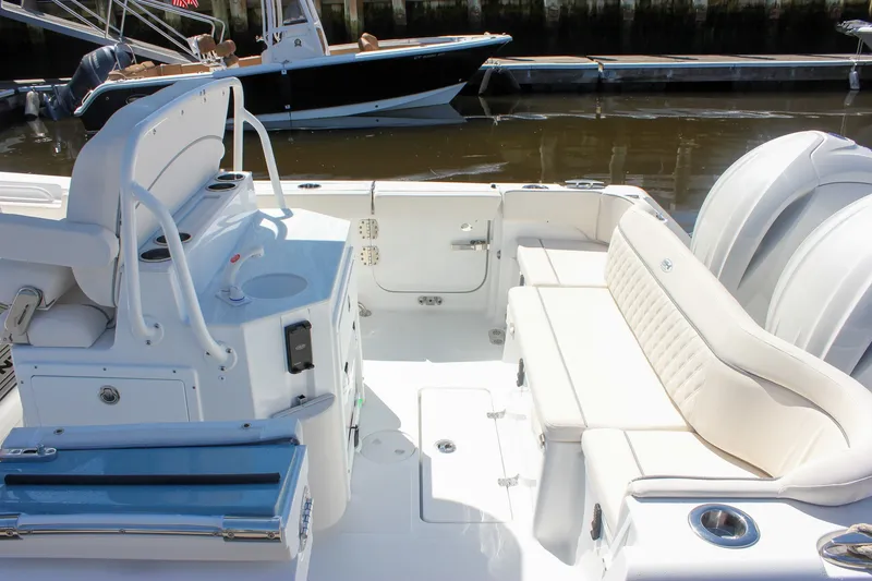 Slide: The Image of 2027 Sea Hunt Ultra 265SE boat interior with white seating and helm station. - 5