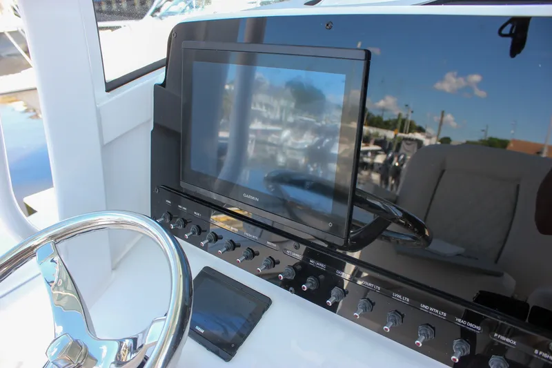 Slide: The Image of Control panel of 2027 Sea Hunt Ultra 265SE boat with Garmin display and steering wheel. - 30