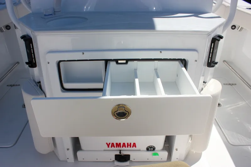 Slide: The Image of 2027 Sea Hunt Ultra 265SE boat with open storage compartment and Yamaha branding. - 13