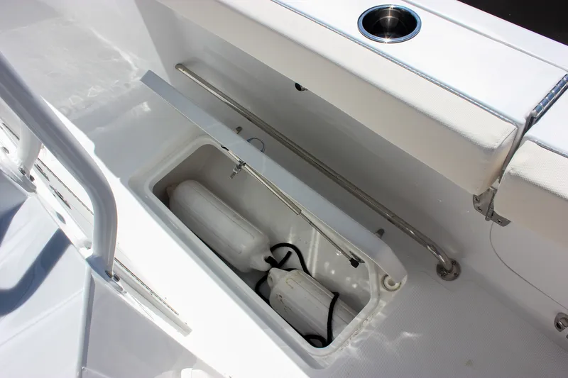 Slide: The Image of Storage compartment on 2027 Sea Hunt Ultra 265SE boat with fenders and cup holder. - 25