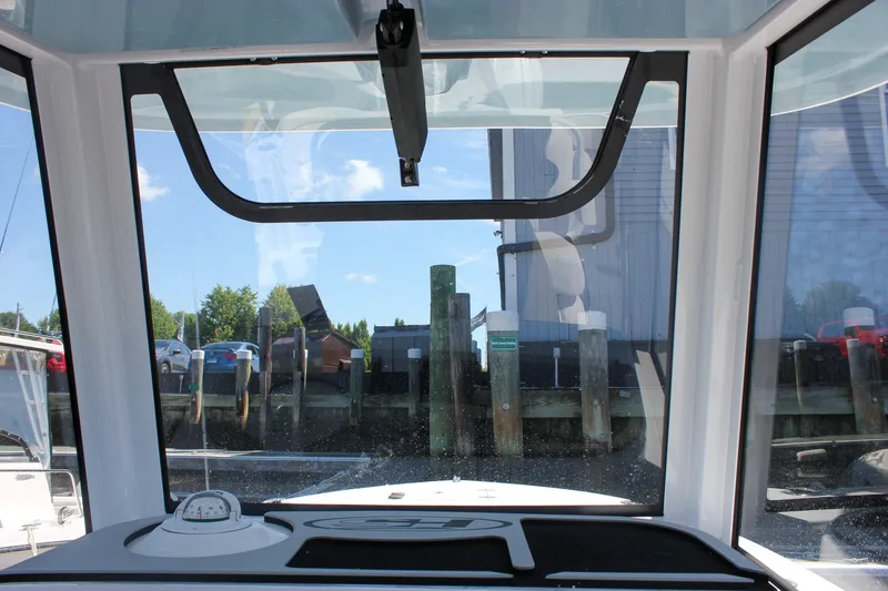 Slide: The Image of Interior view from a 2027 Sea Hunt Ultra 265SE boat, showcasing the windshield and dock. - 31