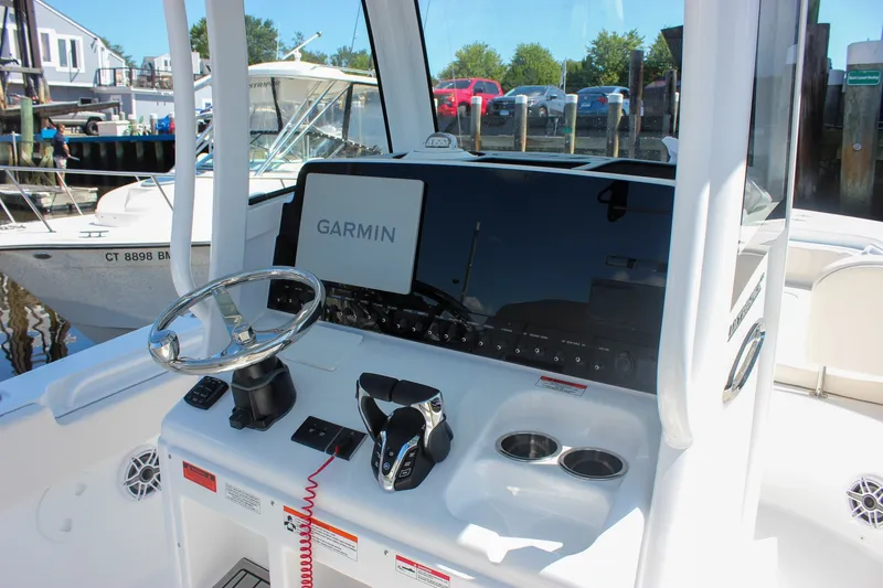 Slide: The Image of 2027 Sea Hunt Ultra 265SE boat dashboard with Garmin navigation system and steering wheel. - 26
