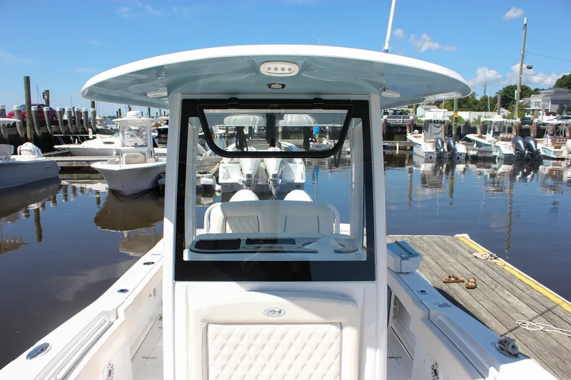 Slide: The Image of 2027 Sea Hunt Ultra 265SE boat docked at a marina under clear blue skies. - 39