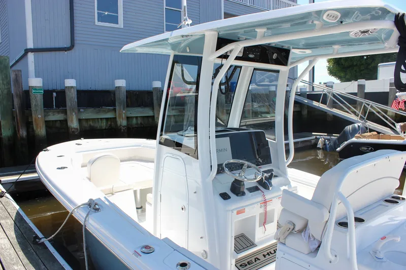 Slide: The Image of 2027 Sea Hunt Ultra 265SE boat docked, featuring a sleek console and spacious seating. - 46