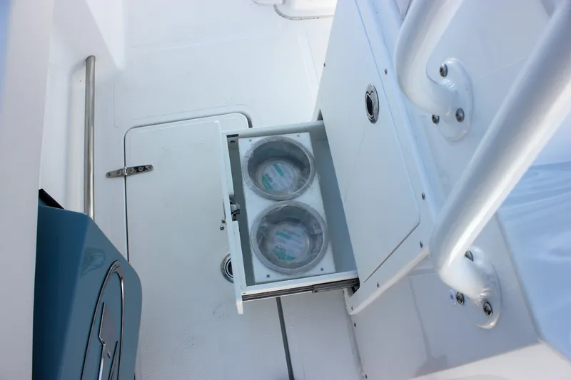 Slide: The Image of 2027 Sea Hunt Ultra 265SE boat interior with open storage compartment and metal railing. - 45