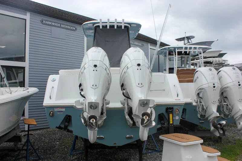 Slide: The Image of 2027 Sea Hunt Ultra 265SE boat with dual outboard engines at a showroom. - 48