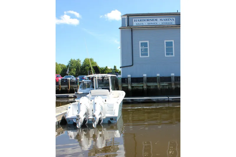 Slide: The Image of Sea Hunt Ultra 265SE 2027 boat docked at Harborside Marina under clear blue sky. - 56