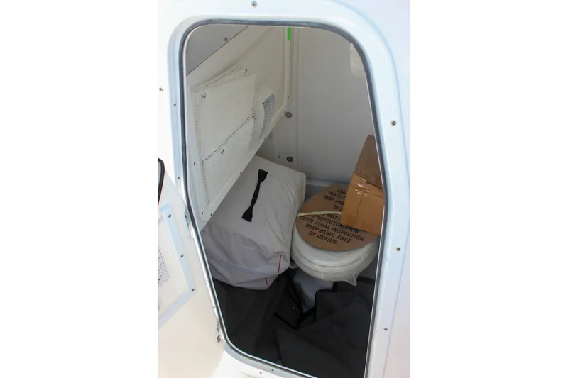 Slide: The Image of Storage compartment of 2027 Sea Hunt Ultra 265SE boat with various items inside. - 42