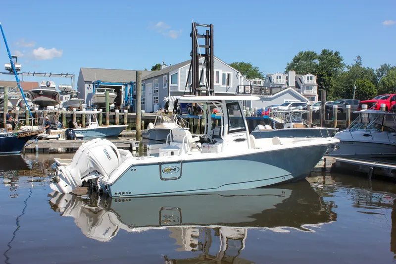 Slide: The Image of 2027 Sea Hunt Ultra 265SE boat docked at marina, featuring dual Yamaha engines. - 54