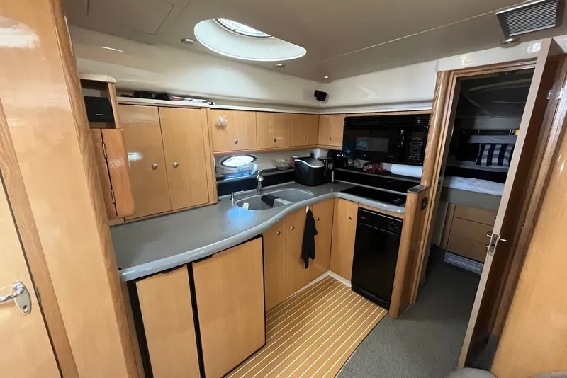 Slide: The Image of 2004 Maxum 4200 SY yacht interior kitchen with wooden cabinets and modern appliances. - 5
