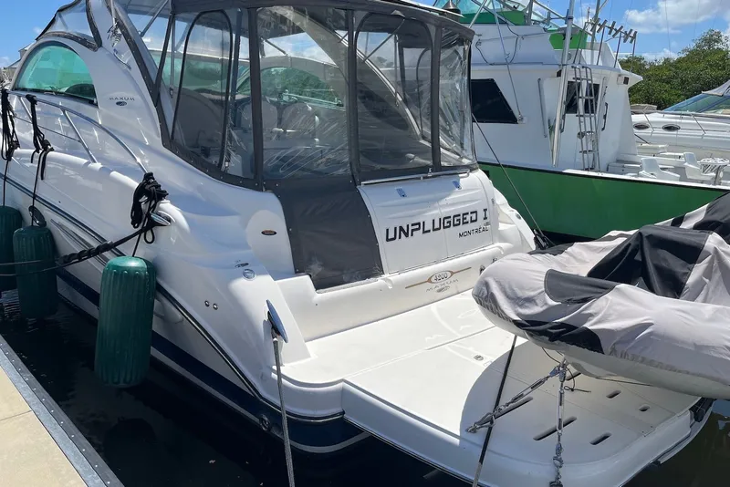 Slide: The Image of 2004 Maxum 4200 SY yacht docked, featuring covered seating and "Unplugged I" name. - 1