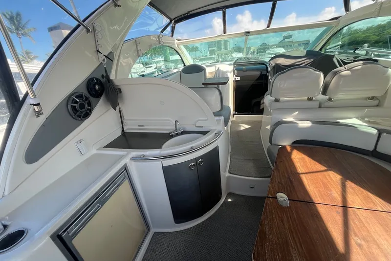 Slide: The Image of 2004 Maxum 4200 SY yacht interior with kitchenette, seating, and wooden table. - 3