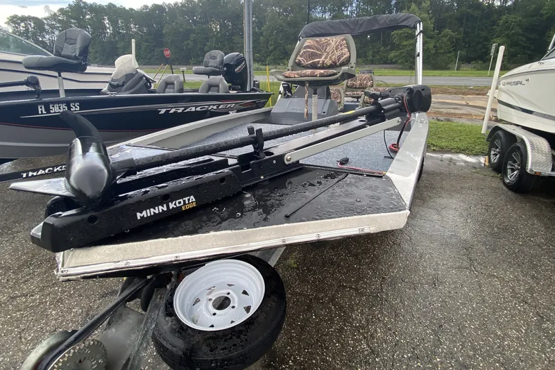 The Image of 1991 Bass Tracker Pro 17 boat with Minn Kota Edge trolling motor on wet pavement. - 1
