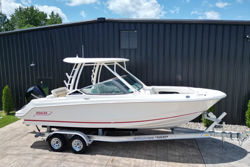 Slide: The Image of 2025 Boston Whaler 240 Vantage boat on trailer, parked outdoors. - 17