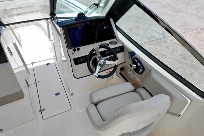 Slide: The Image of 2025 Boston Whaler 240 Vantage helm with steering wheel and navigation controls. - 9