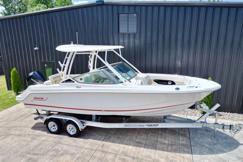 Slide: The Image of 2025 Boston Whaler 240 Vantage boat on trailer, parked outdoors. - 15